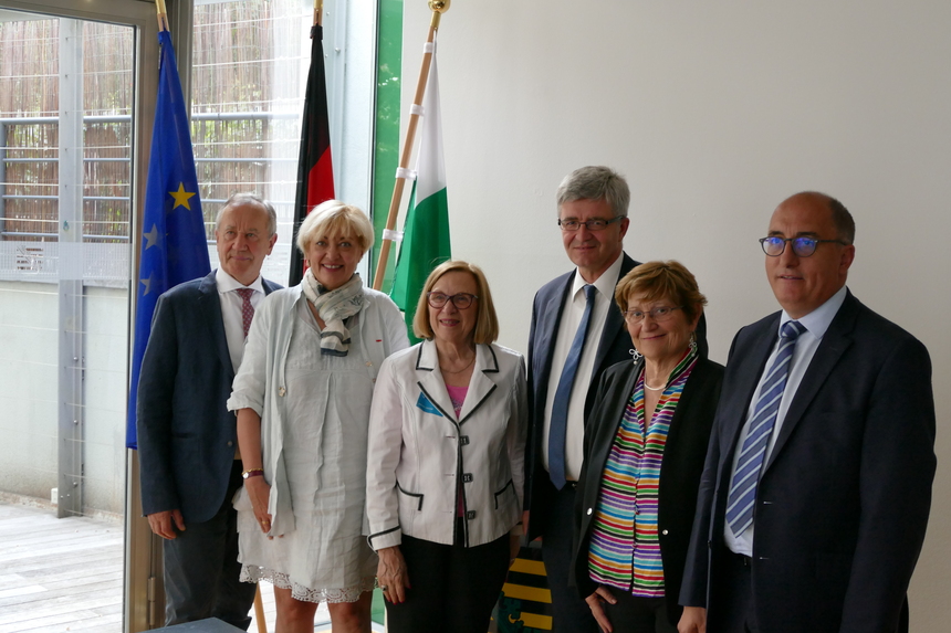 Gruppenfoto mit Dienststellenleiter stehend vor Fahne 