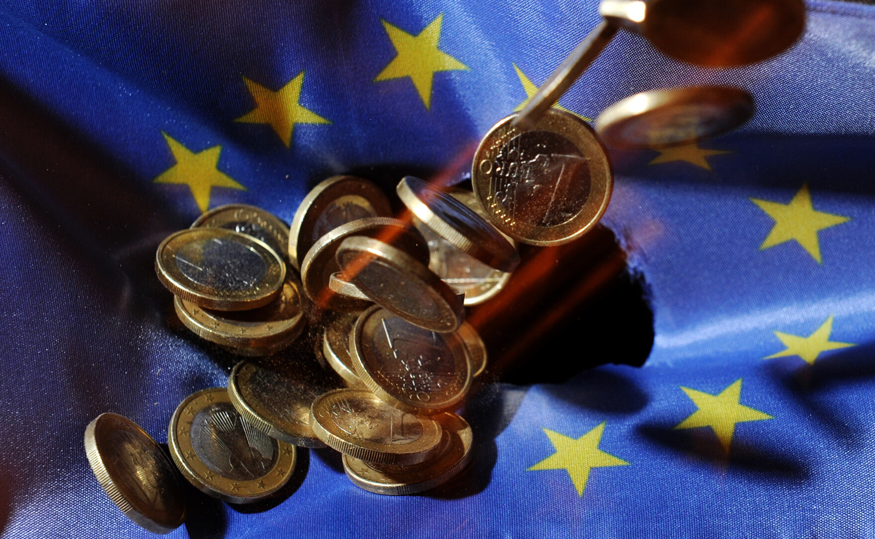Kleingeld liegt in einer EU-Fahne.